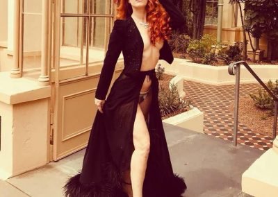 location shot of Kelly Ann Doll in Adelaide, she is wearing a black skirt with a black tuxedo jacket in Botanic Gardens Adelaide
