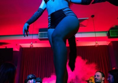 Burlesque Dancer Kelly Ann Doll live on a table performing at Wanted and Wild Burlesque