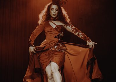 Image of a burlesque dancer on stage wearing a red costume at The Vanguard Sydney